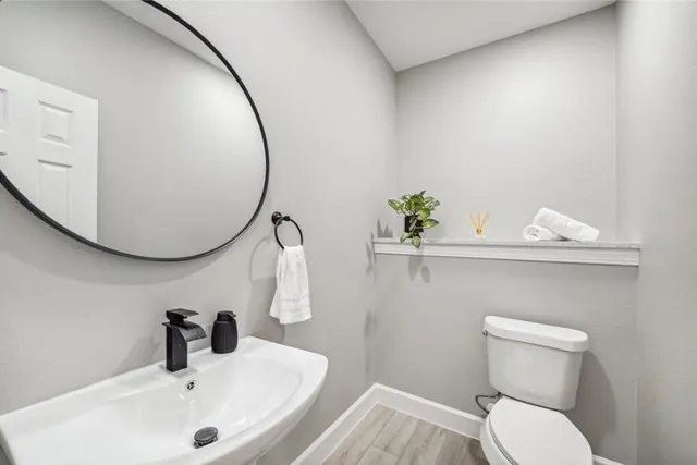a bathroom with a sink mirror and toilet