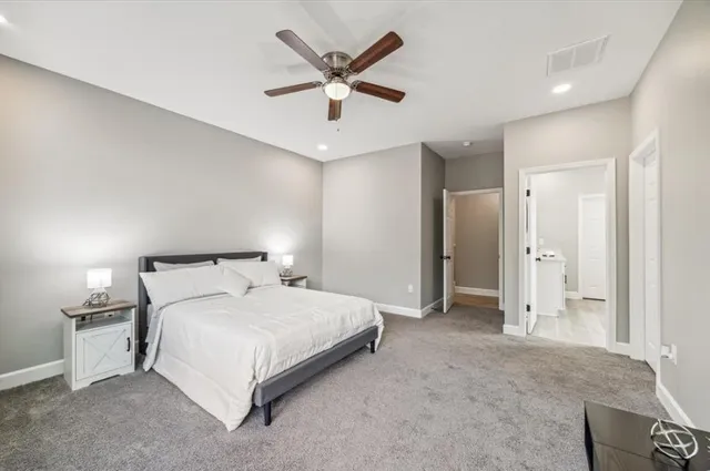 a bedroom with a large bed chandelier and a window
