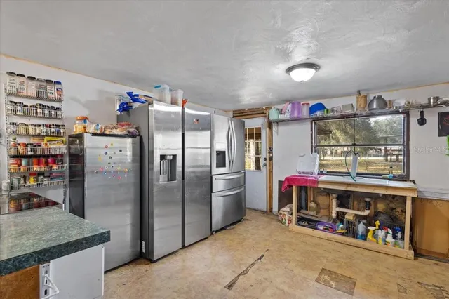 a kitchen with refrigerator and wooden floor