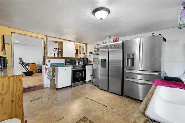 a kitchen with stainless steel appliances granite countertop a refrigerator a stove and a sink