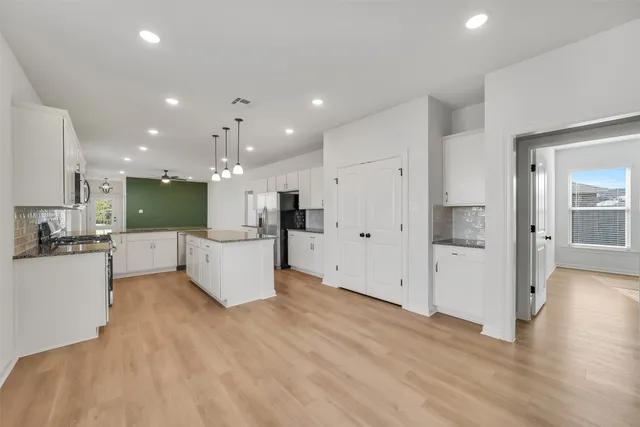a view of kitchen with kitchen island white cabinets and refrigerator