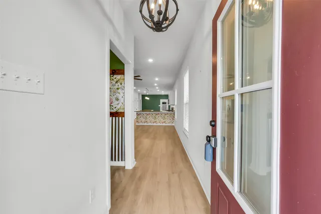 a view of a hallway with wooden floor and entryway