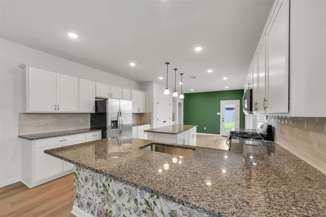a large kitchen with a large counter top appliances and cabinets