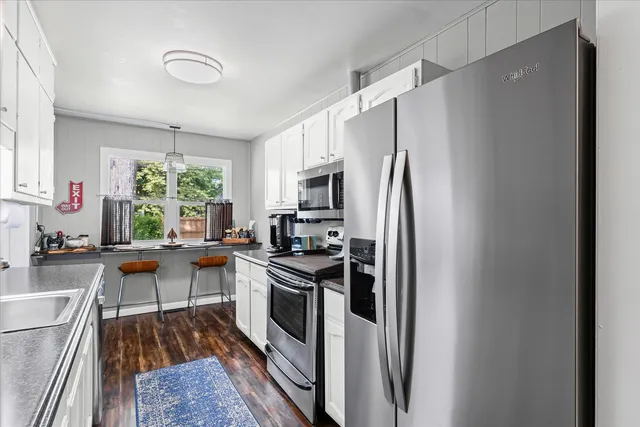 a kitchen with stainless steel appliances granite countertop a refrigerator stove and sink