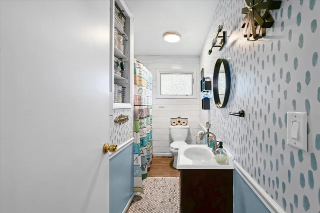 a bathroom with a sink toilet and mirror