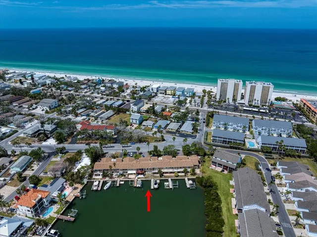 an aerial view of a city with lots of residential buildings and ocean view in back