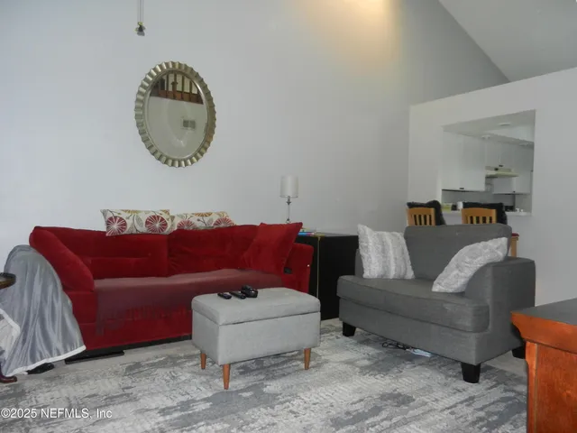 a living room with a couch and a mirror