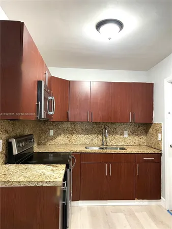 a kitchen with stainless steel appliances granite countertop a sink stove and cabinets