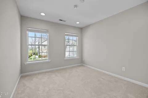 an empty room with windows and ceiling fan