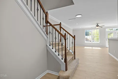 a view of a hallway with wooden floor and staircase