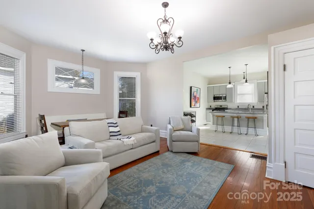 a living room with furniture and a chandelier