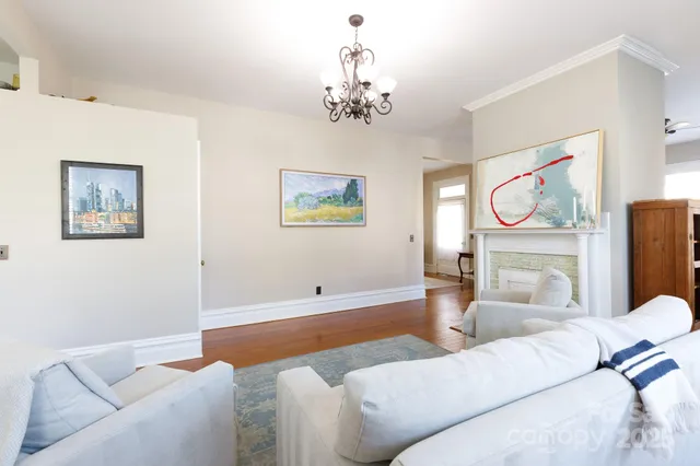 a living room with furniture a chandelier and a window