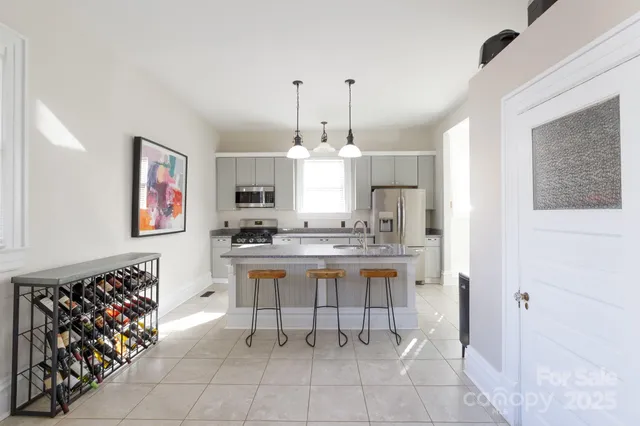 a large white kitchen with cabinets furniture and a wooden floor