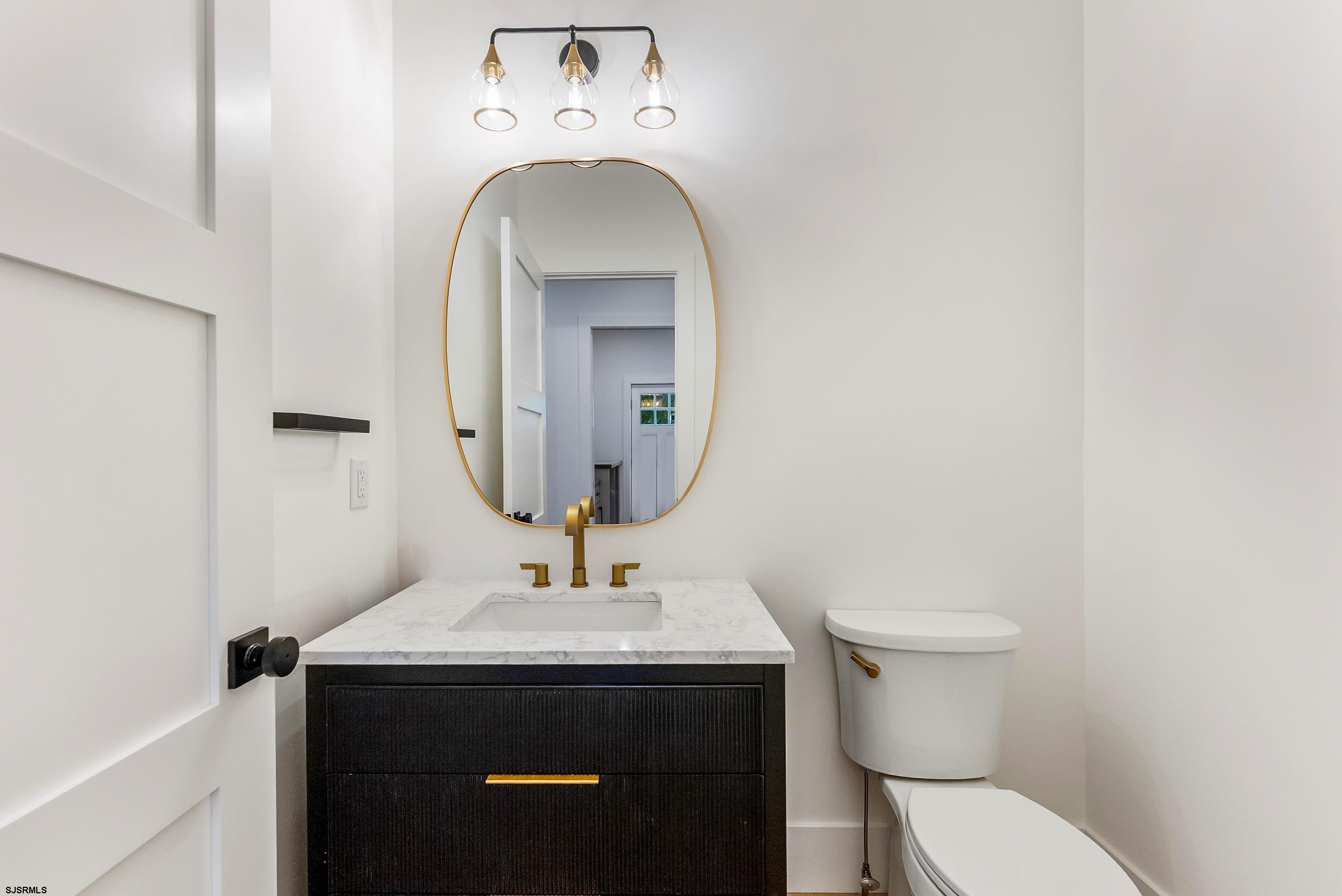 11 Evio John Court Marmora, NJ 08223 - Photo 25 of 49 a bathroom with a toilet sink and mirror