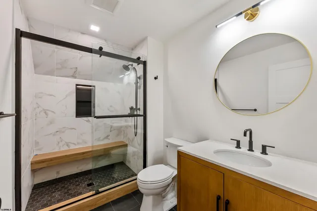 a bathroom with a granite countertop sink toilet and shower