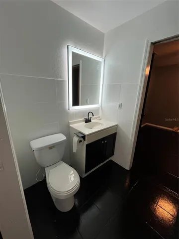 a view of an empty room with wooden floor and stairs