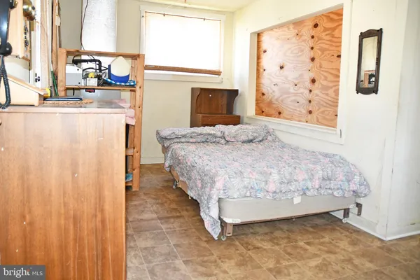 a bedroom with a bed dresser and a window