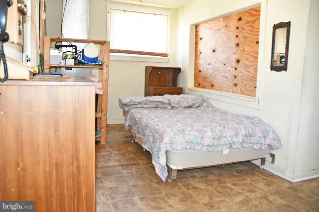 a bedroom with a bed dresser and a window