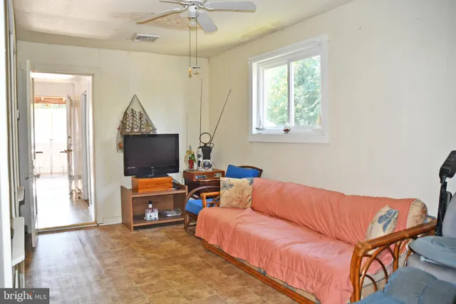 a living room with furniture a flat screen tv and a window