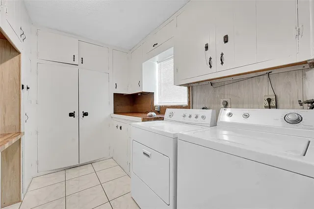 a utility room with cabinets washer and dryer