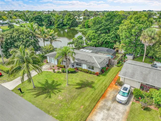a aerial view of a house with a yard and lake view