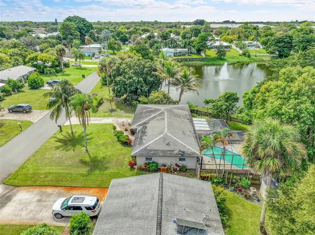 an aerial view of residential houses with outdoor space and trees