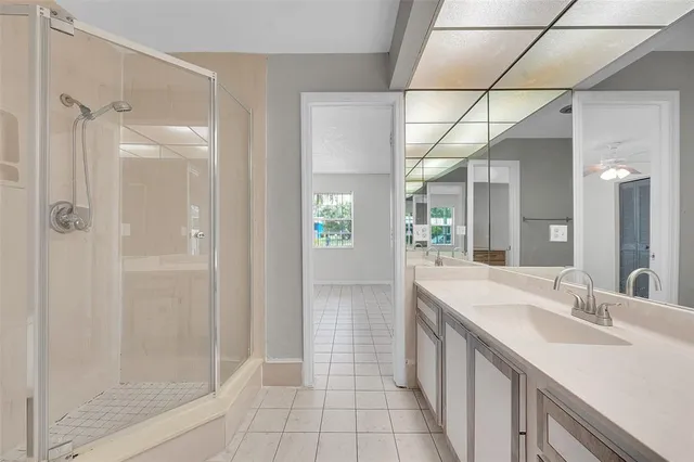 a bathroom with a double vanity sink a large mirror and shower