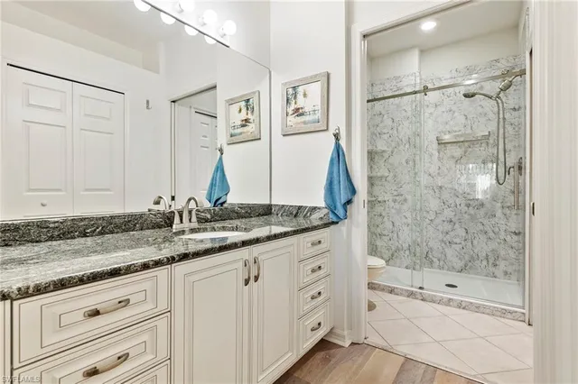 a bathroom with a granite countertop sink a mirror and a bathtub