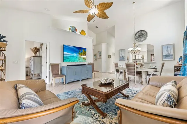 a living room with furniture kitchen view and a chandelier
