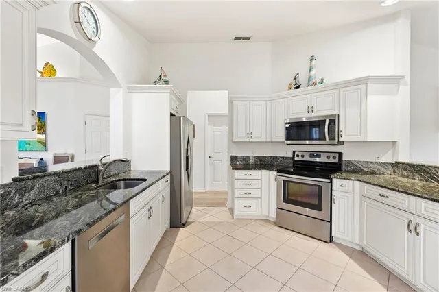 a kitchen with stainless steel appliances granite countertop a sink and a stove