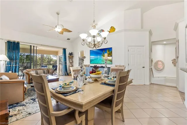 a view of a dining room with furniture a chandelier and large windows