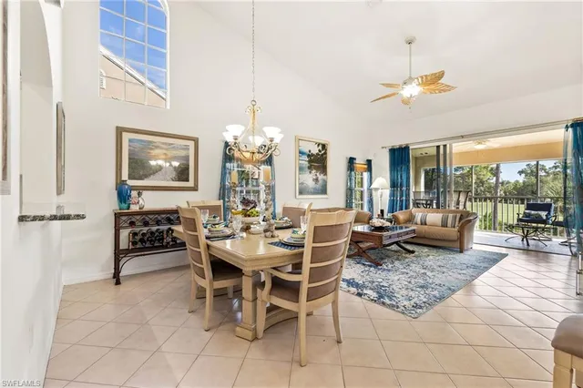 a dining room with wooden floor a chandelier a wooden table and chairs