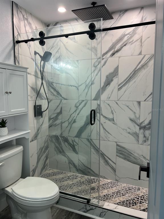 13246 4th Street East Madeira Beach, FL 33708 - Photo 14 of 23 a white toilet sitting next to a shower