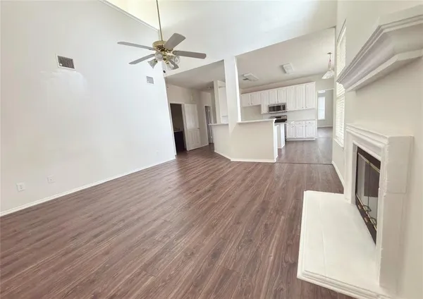 a view of a kitchen with wooden floor and a ceiling fan