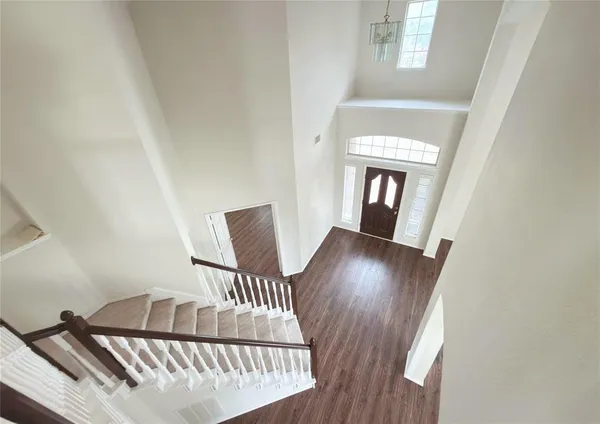 a view of a livingroom with wooden floor and staircase