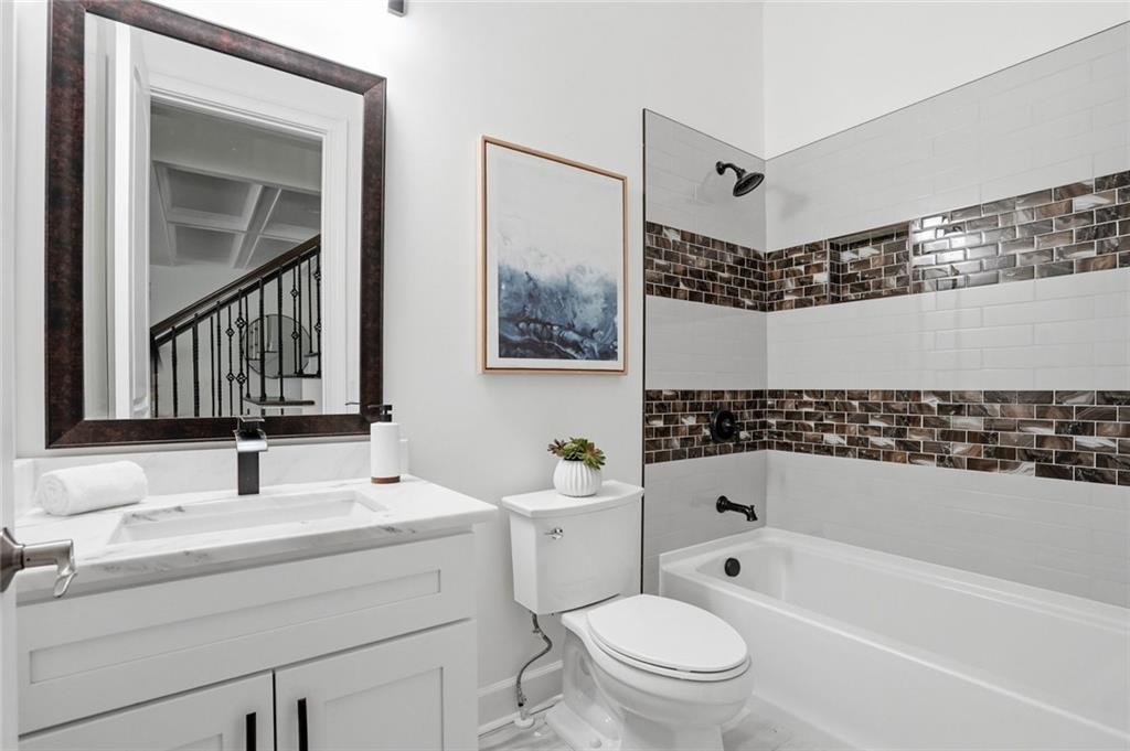 2415 West Rugby Avenue Atlanta, GA 30337 - Photo 29 of 40 a bathroom with a bathtub shower sink vanity mirror and toilet