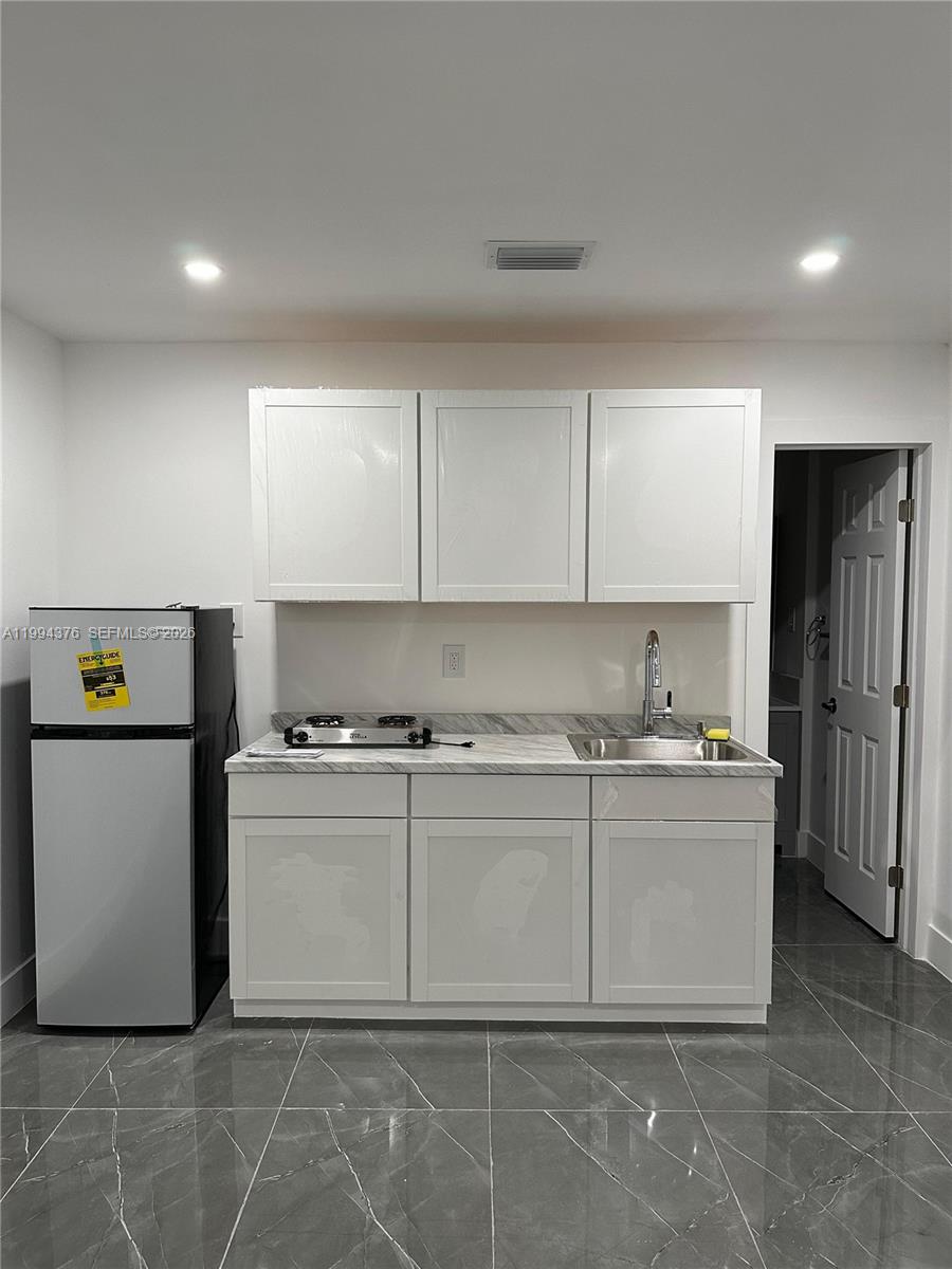 a kitchen with stainless steel appliances granite countertop a refrigerator a stove and a sink