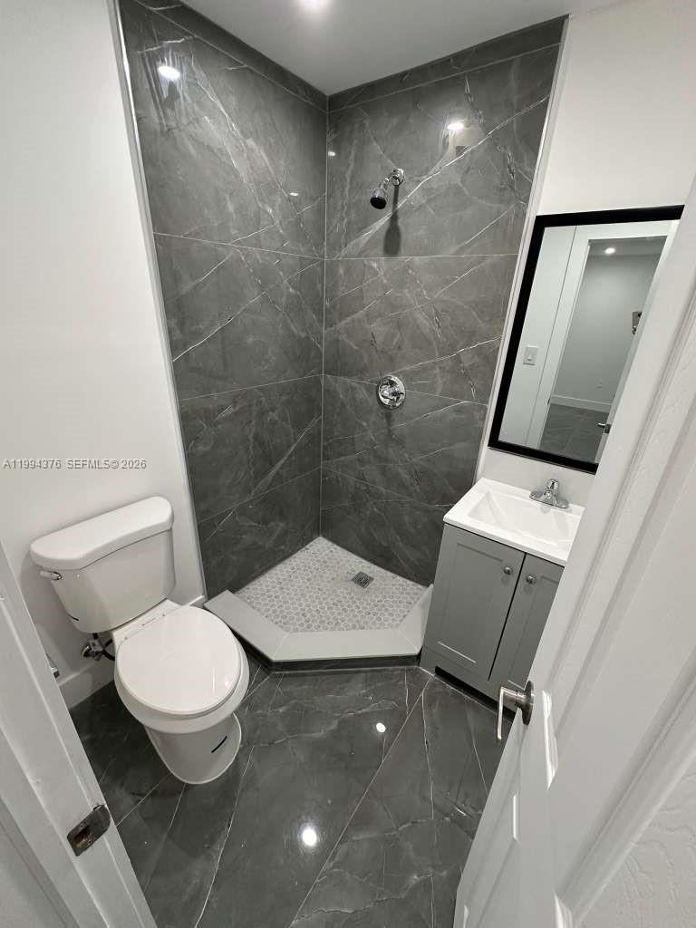 10825 Southwest 145th Place, Unit 2 Miami, FL 33186 - Photo 4 of 6 a bathroom with a toilet a sink and shower