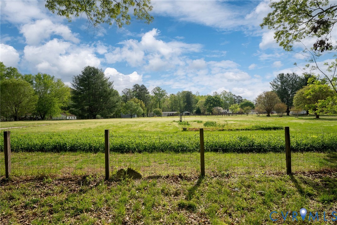 7381 McClellan Road Mechanicsville, VA 23111 - Photo 22 of 66 Expansive green field with a wire fence and wooden