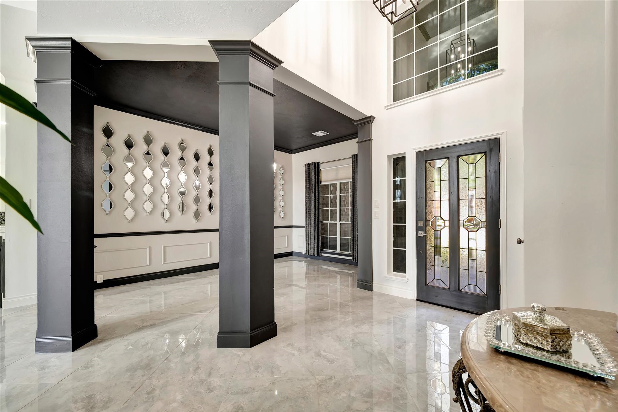2847 Everett Drive Friendswood, TX 77546 - Photo 11 of 50 This photo showcases a modern entryway with high ceilings and large windows, allowing ample natural light with the formal dining room