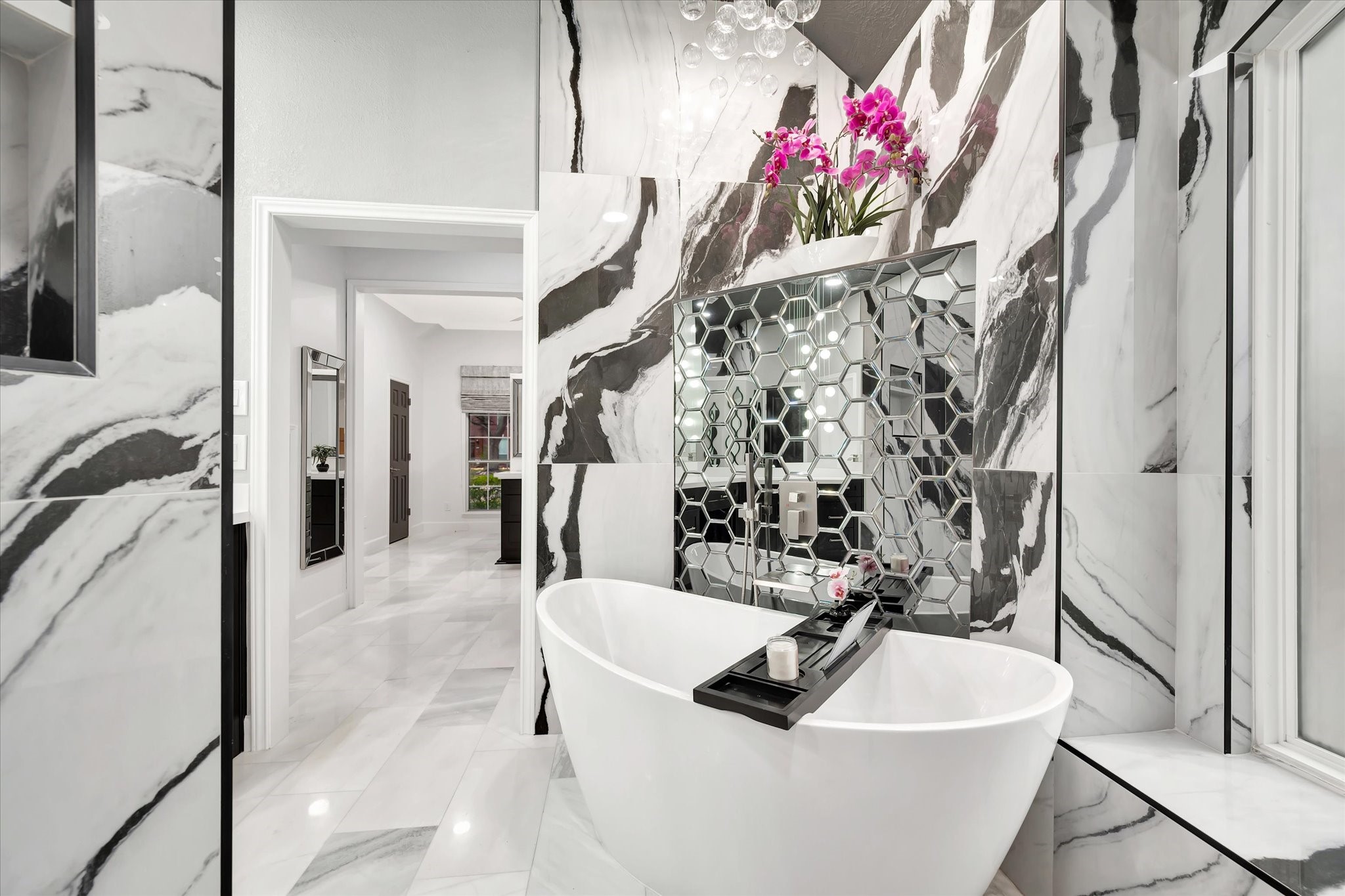 2847 Everett Drive Friendswood, TX 77546 - Photo 37 of 50 This luxurious bathroom features elegant marble floors, a modern freestanding bathtub, and a stylish hexagonal mirrored accent. The bright, spacious design is complemented by chic lighting