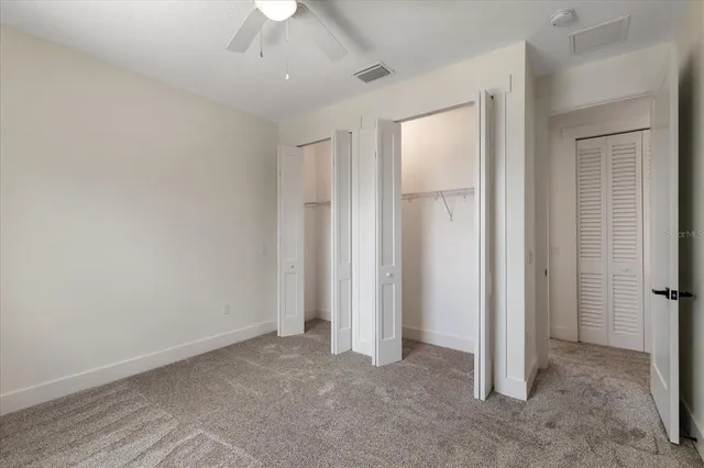 an empty room with a ceiling fan and a window