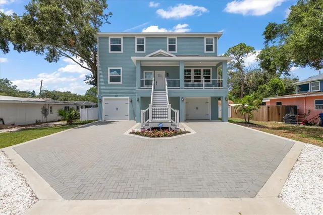 a front view of a house with garden and parking