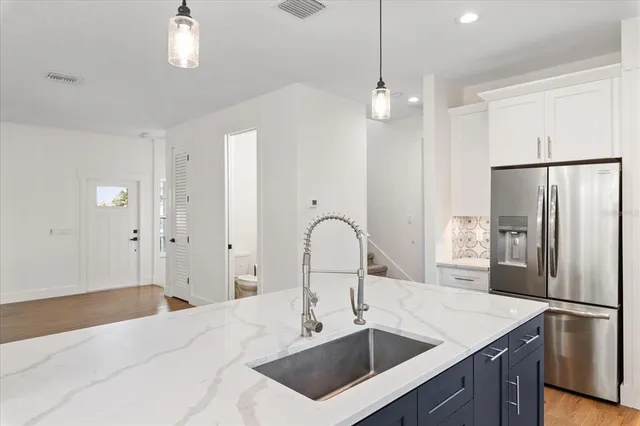 a kitchen with a sink a refrigerator and cabinets
