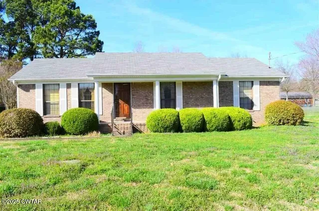 a view of a house with a yard and potted plants