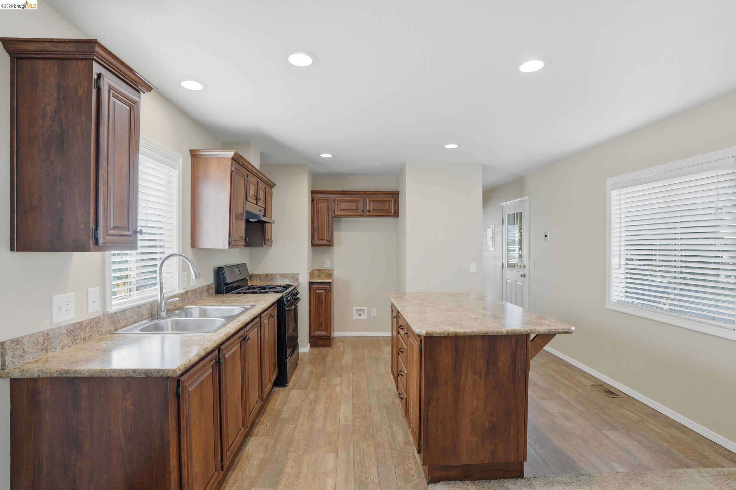 a kitchen with granite countertop cabinets a sink a window and stainless steel appliances