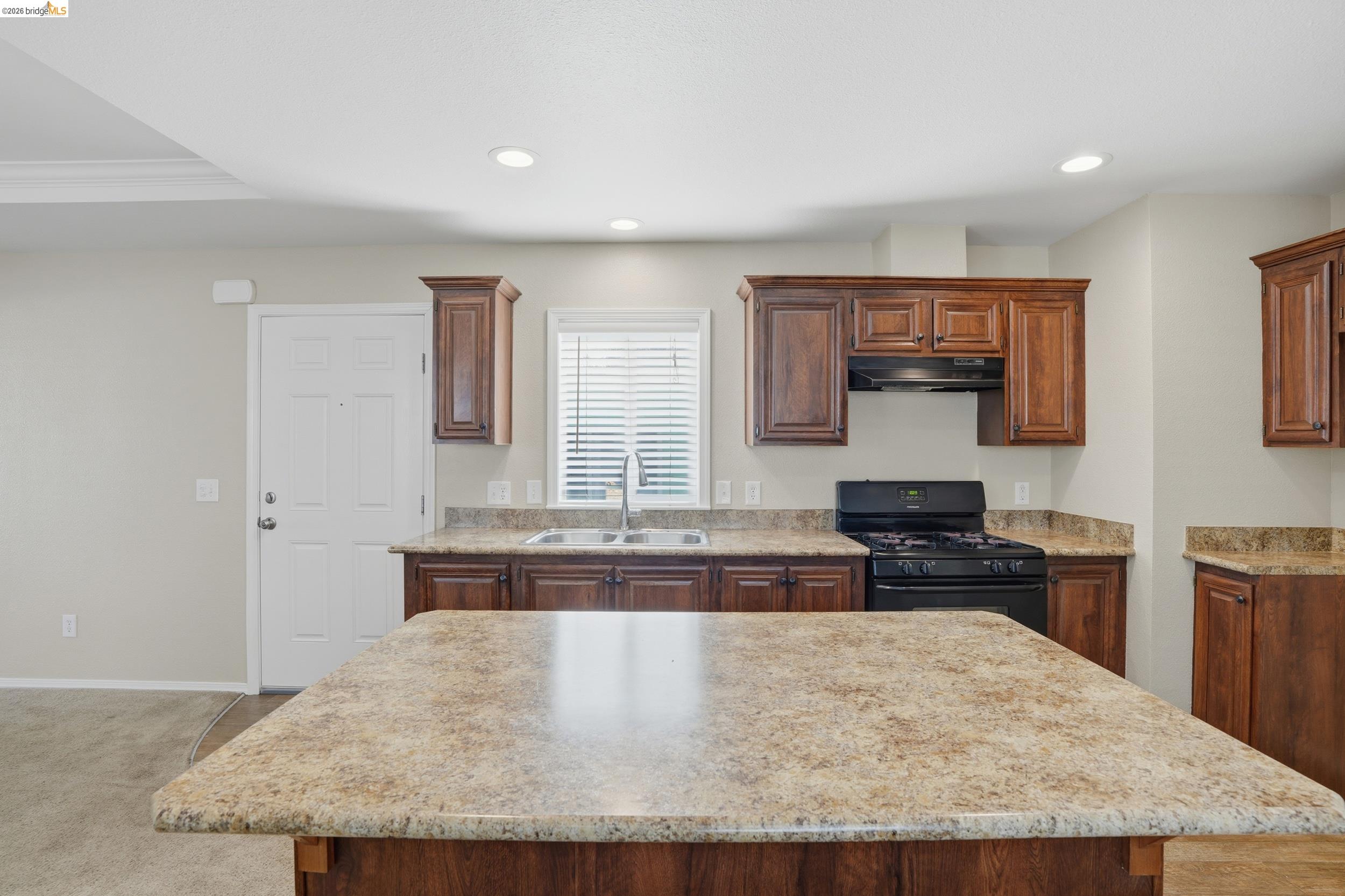 360 East Grant Line Road, Unit SPC 18 Tracy, CA 95376 - Photo 3 of 31 a kitchen with granite countertop a stove a sink and a refrigerator