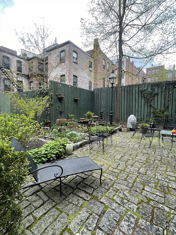 9 Primus Avenue, Unit 1 Boston, MA 02114 - Photo 19 of 19 a backyard of a house with table and chairs