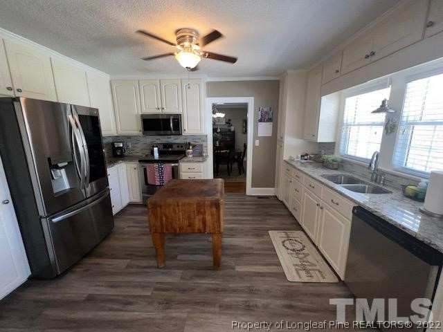 406 Old Post Road Erwin, NC 28339 - Photo 5 of 30 a kitchen with stainless steel appliances granite countertop a refrigerator a stove a sink a dining table and chairs with wooden floor