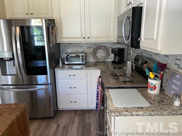 406 Old Post Road Erwin, NC 28339 - Photo 6 of 30 a kitchen with stainless steel appliances granite countertop a refrigerator a stove and a sink with wooden floor